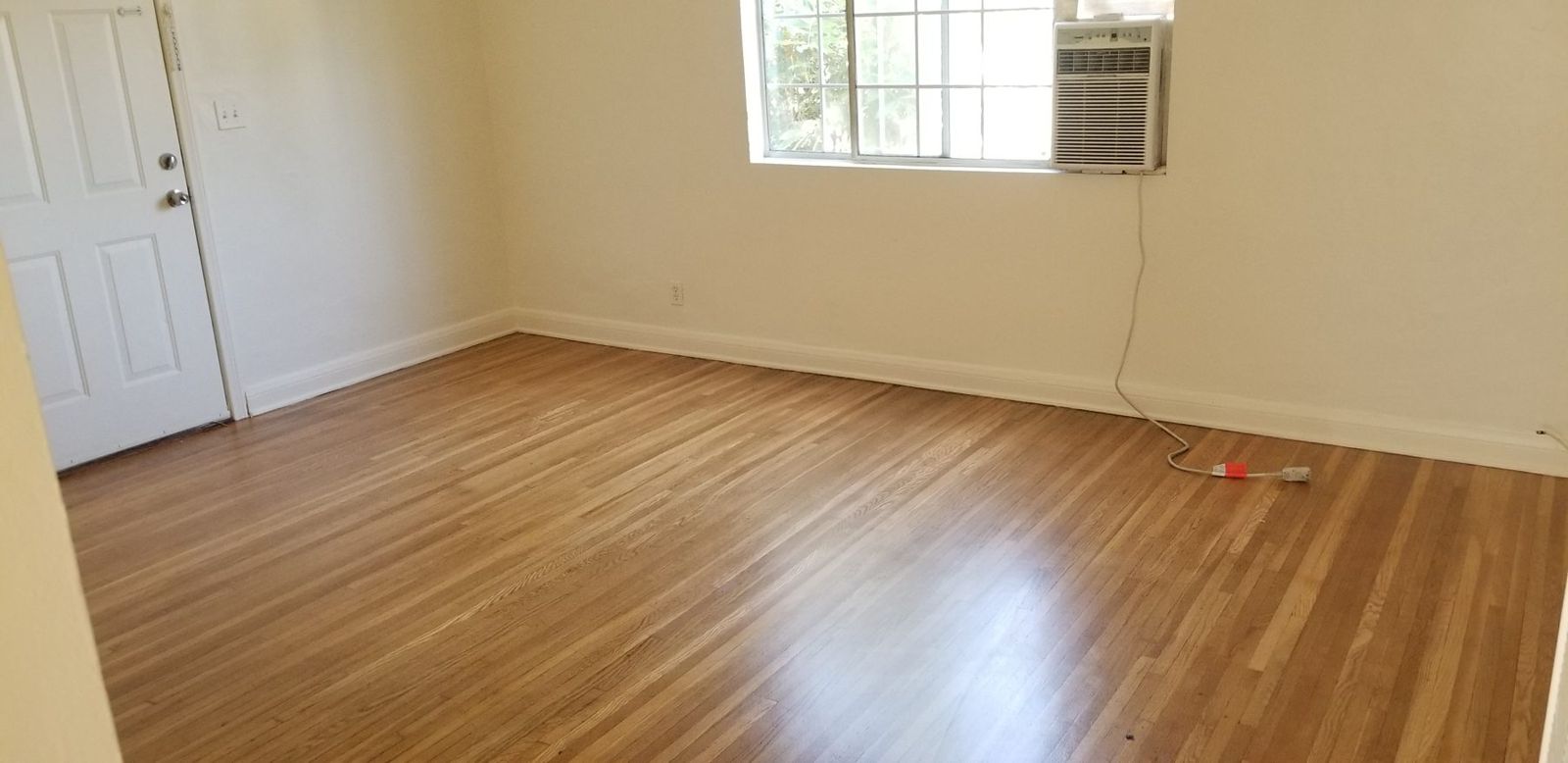 Restored hardwood floor in a bright empty room