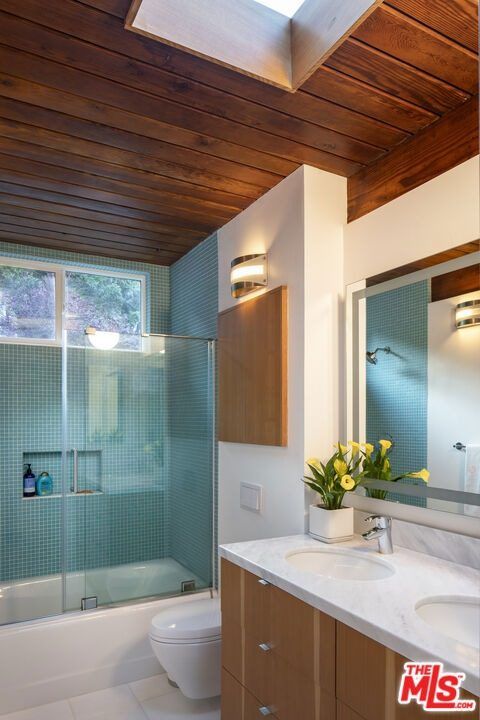 Bathroom with a wood ceiling, skylight and glass shower