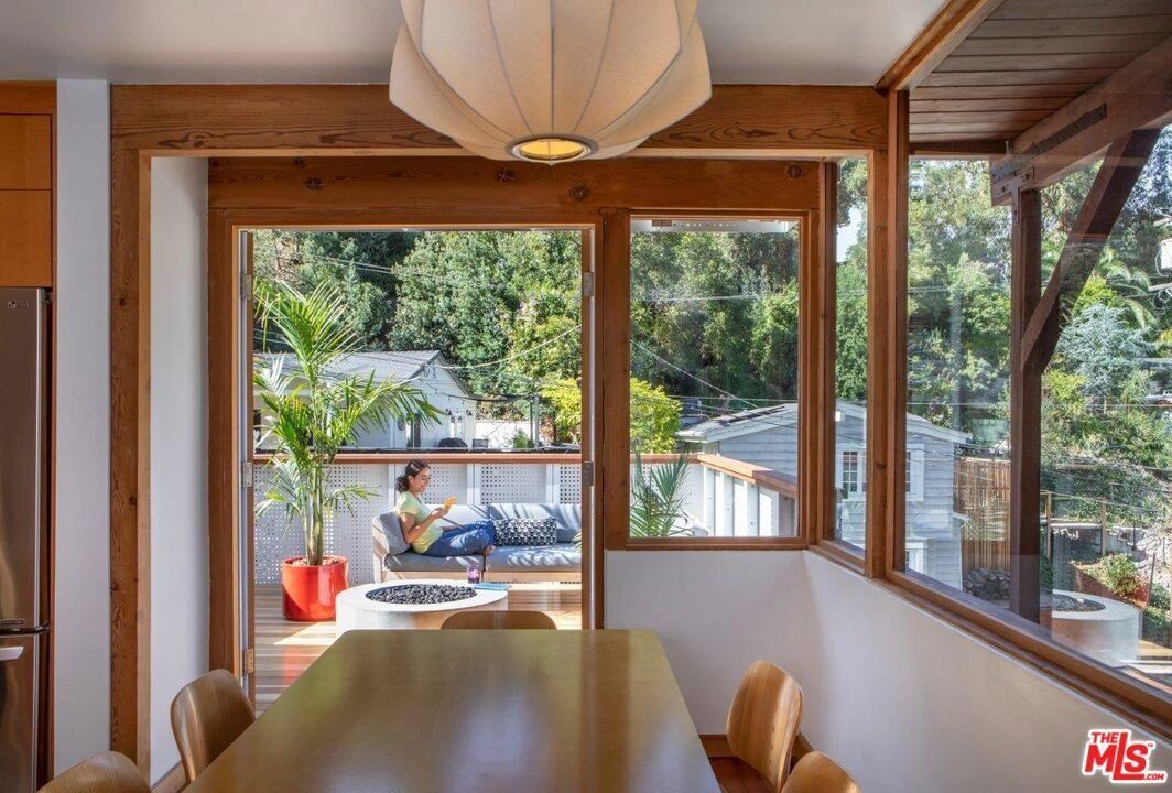 Dining room framed by wood windows looking out to a deck