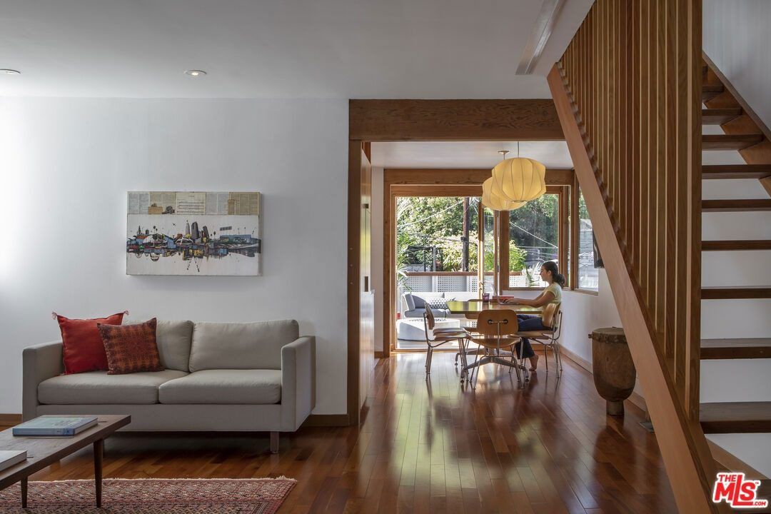 Living room with a gray sofa beside the wood staircase